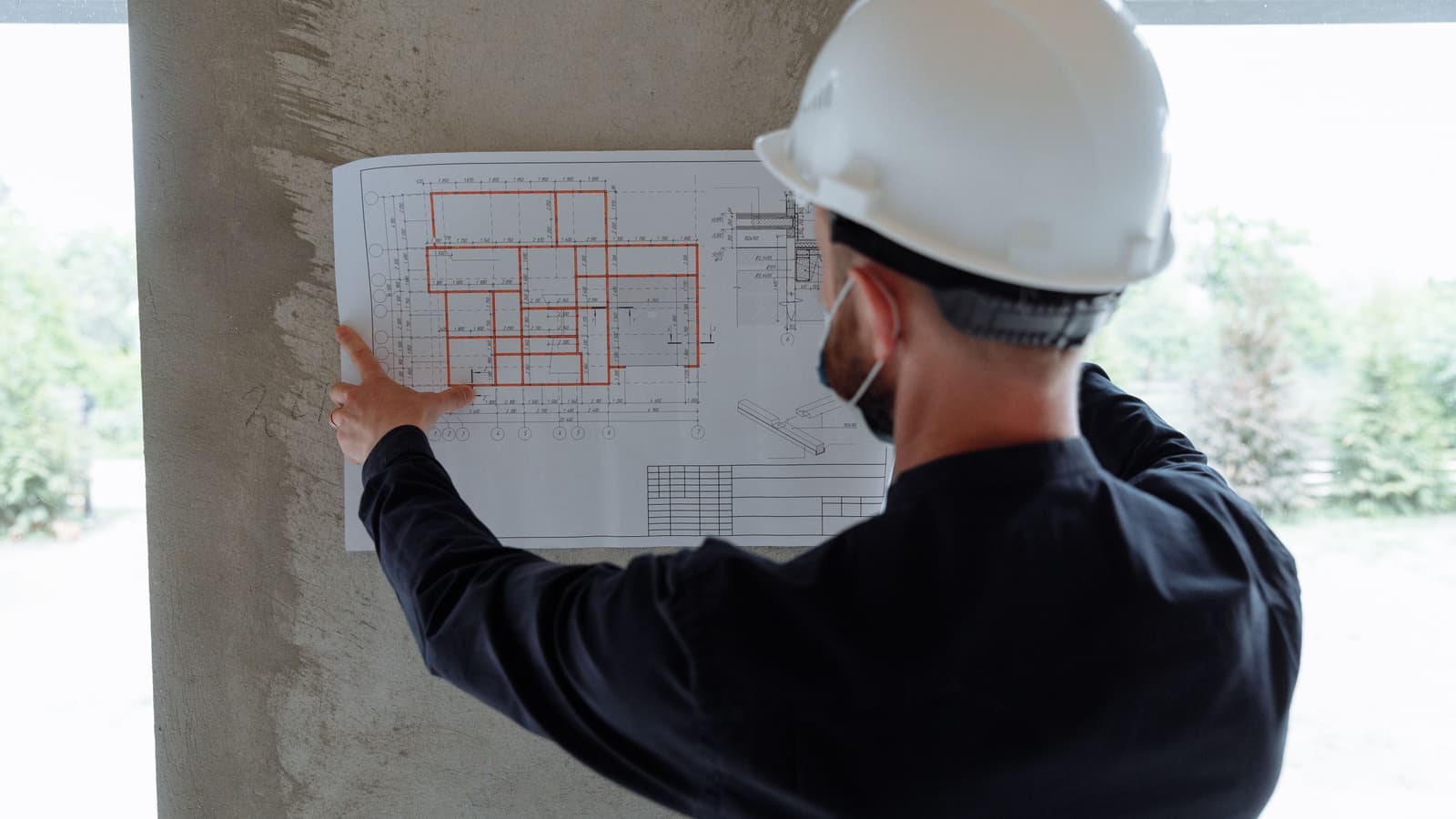 Elektroplan wird vor Ort an der Wand geprüft.